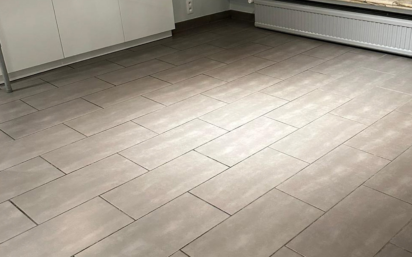 Na — schoongemaakte grijze tegelvloer